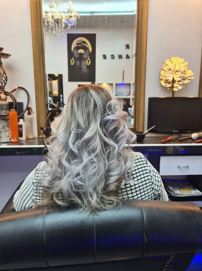 Ženska frizura s plavo-srebrnimi prameni in kodri